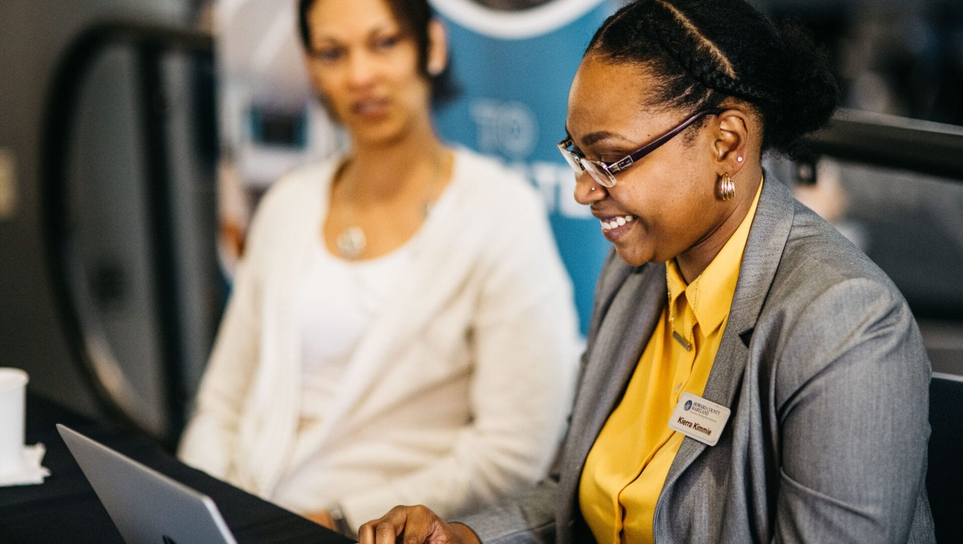 Kierra Kimmie smiling while working at a laptop.